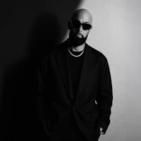 a black and white photo of a man in a suit and sunglasses